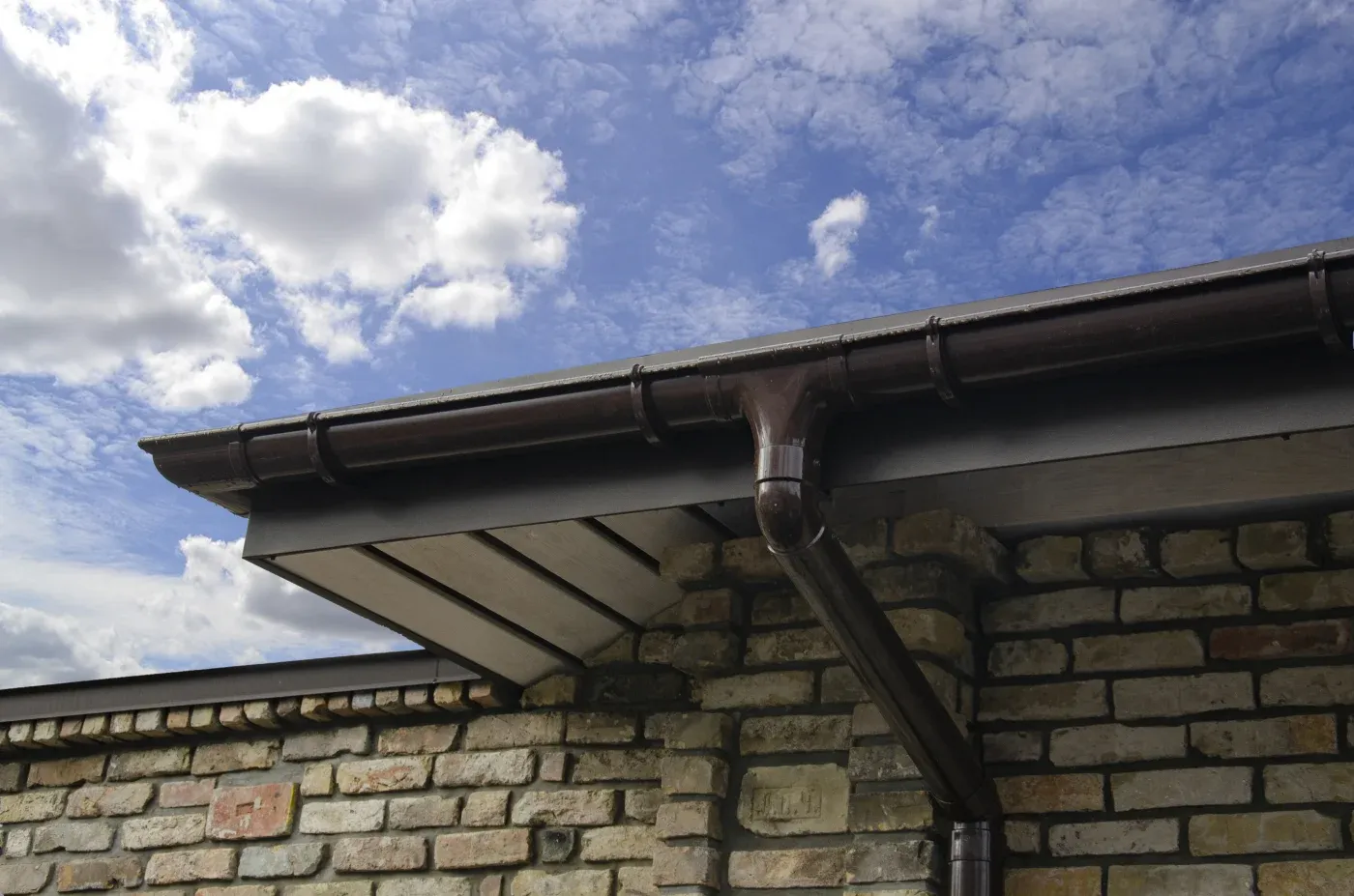 Black seamless gutters against a white house in Atlanta, GA.