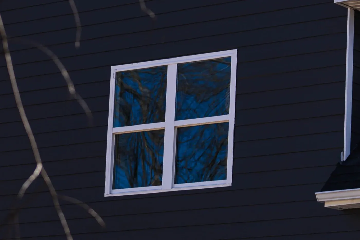 A white-framed replacement window newly installed in a home.