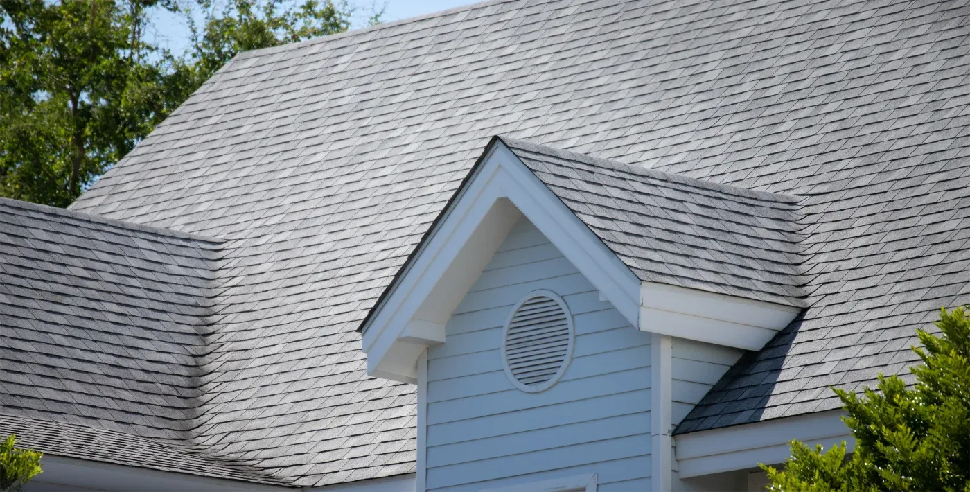 A close-up view of an asphalt shingle roof on a two-story house