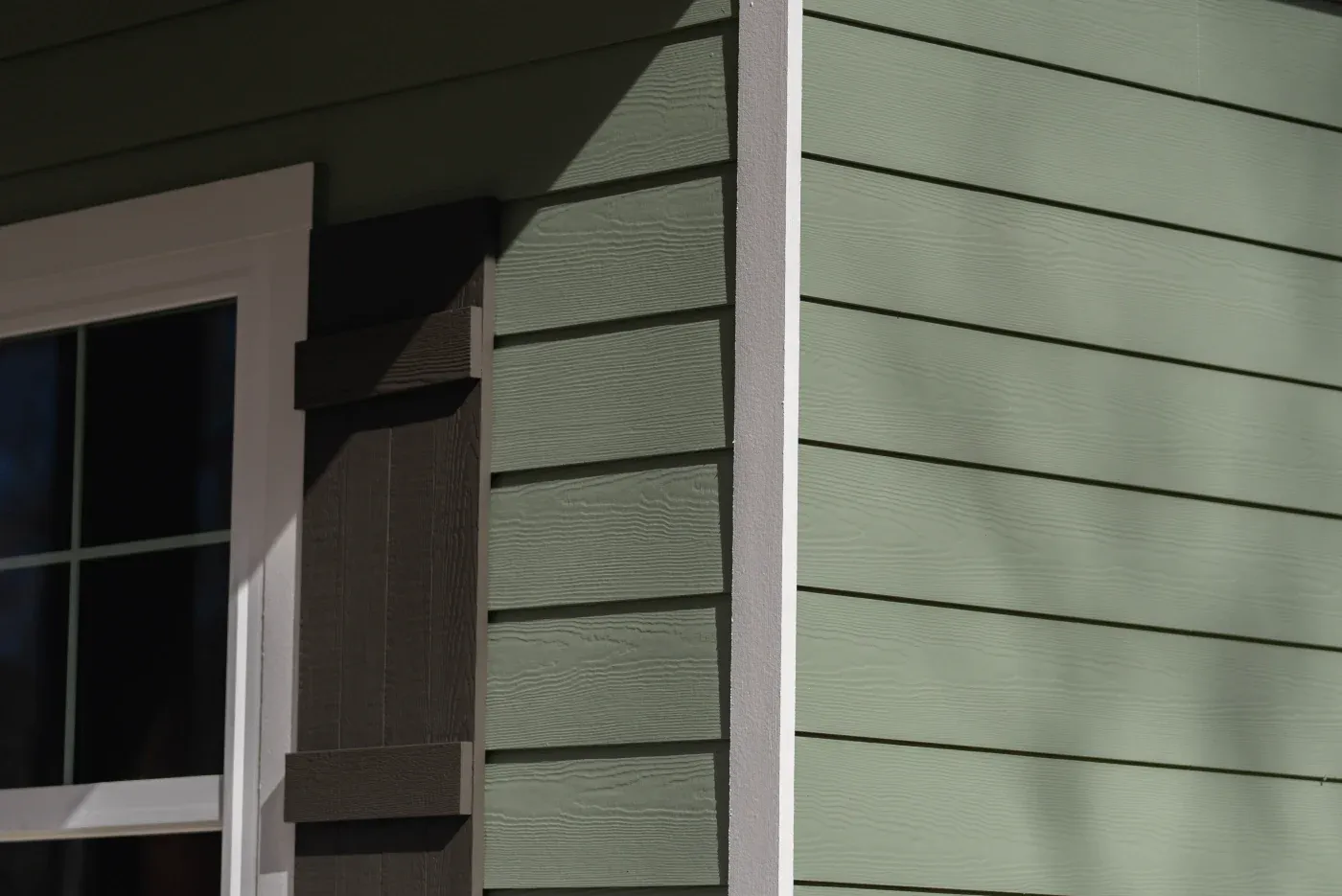 A close-up of sage green siding on a North Atlanta home.