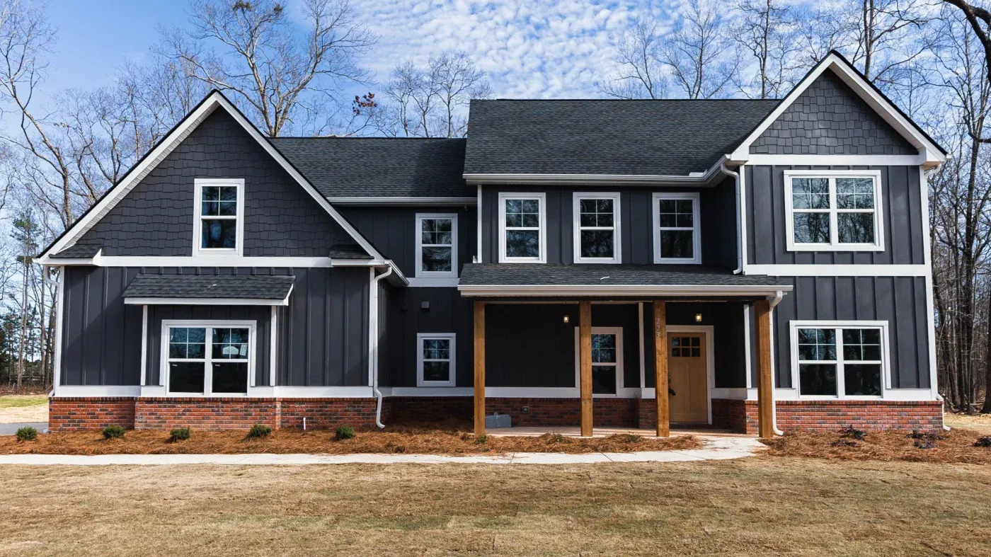 A spacious, beautiful North Atlanta home with dark gray board-and-batten James Hardie siding with white trim and new windows.