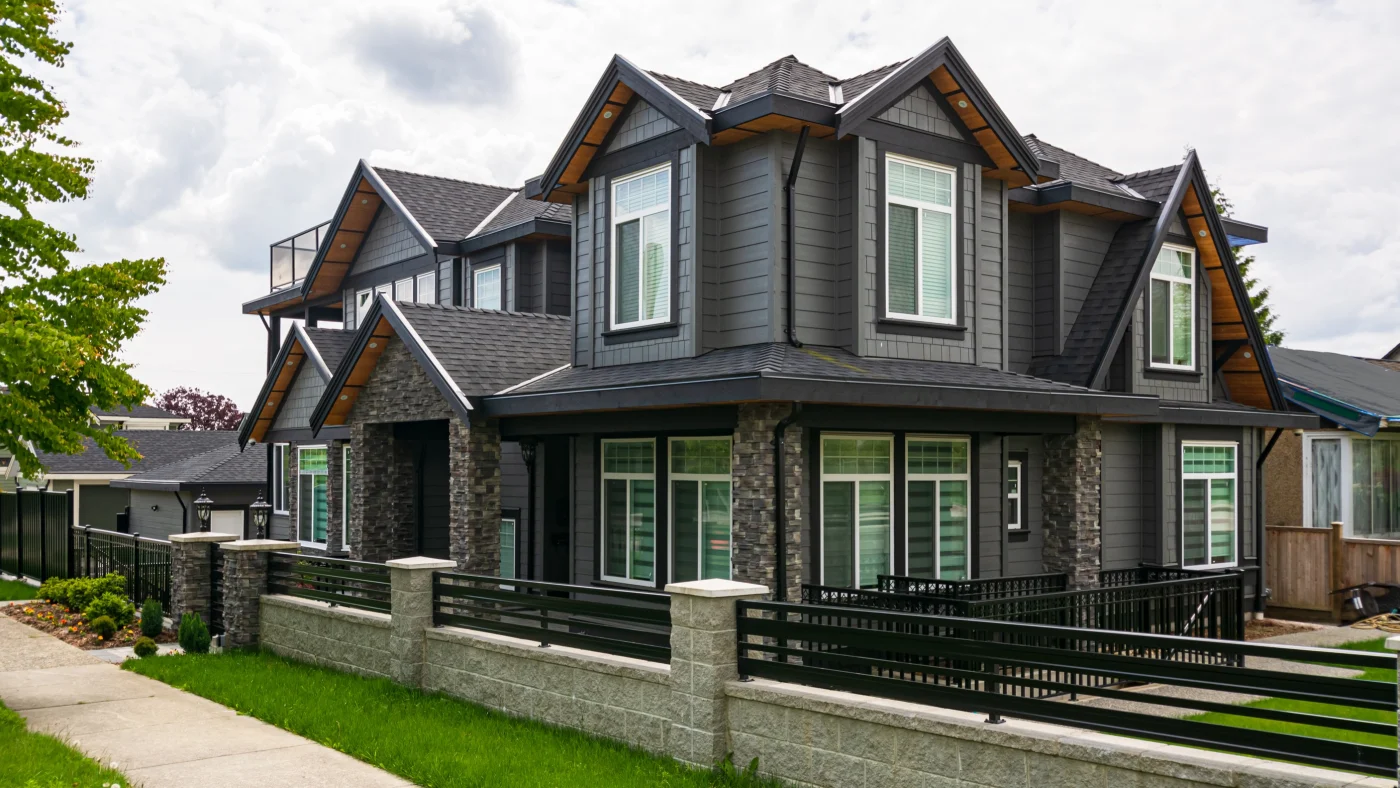 Luxury Residential House With Front Yard Behind Concrete And Metal Fence