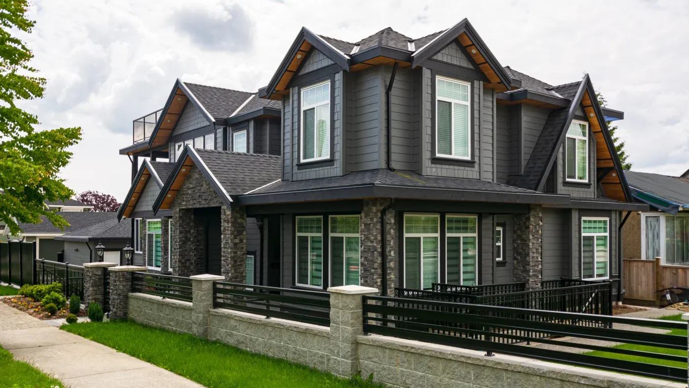 Luxury Residential House With Front Yard Behind Concrete And Metal Fence