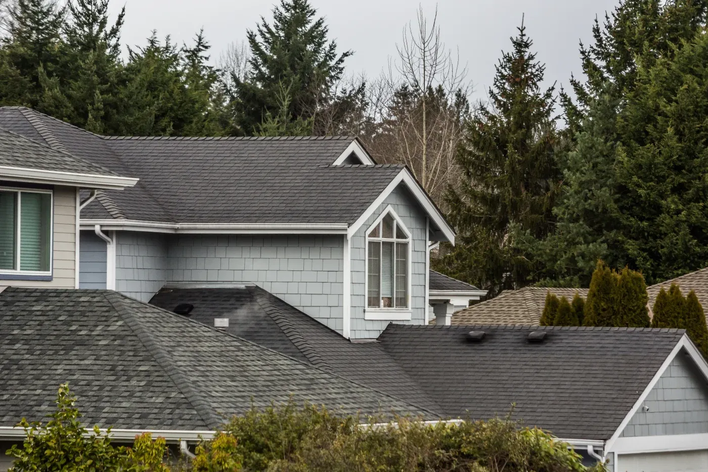 A close-up view of dark, new asphalt shingles installed with precision around a vent.