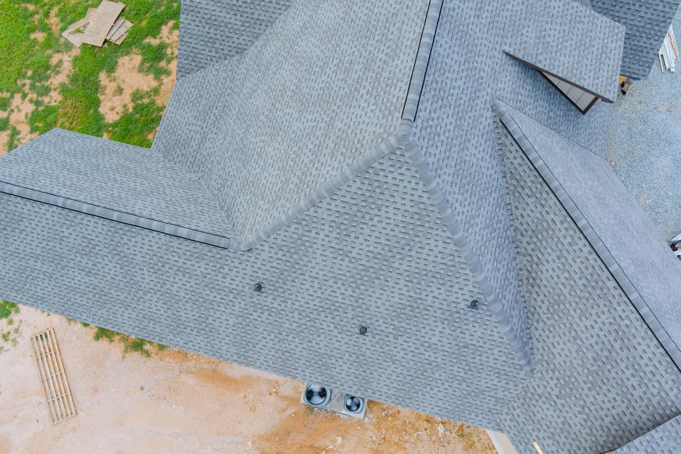 A close-up shot of dark, new asphalt shingles layered perfectly near a valley, emphasizing proper flashing.