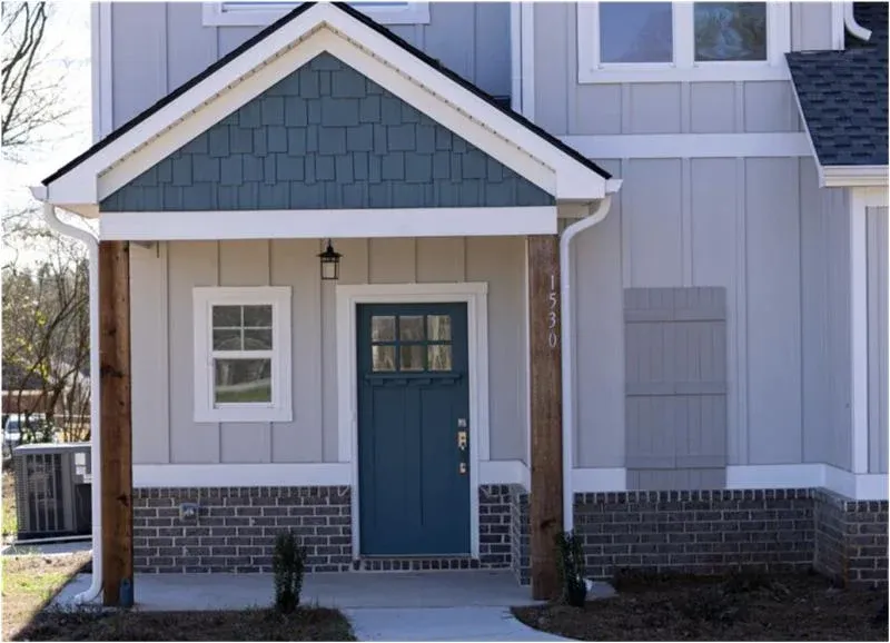A closeup of sliding patio doors in a home with gray vinyl siding.