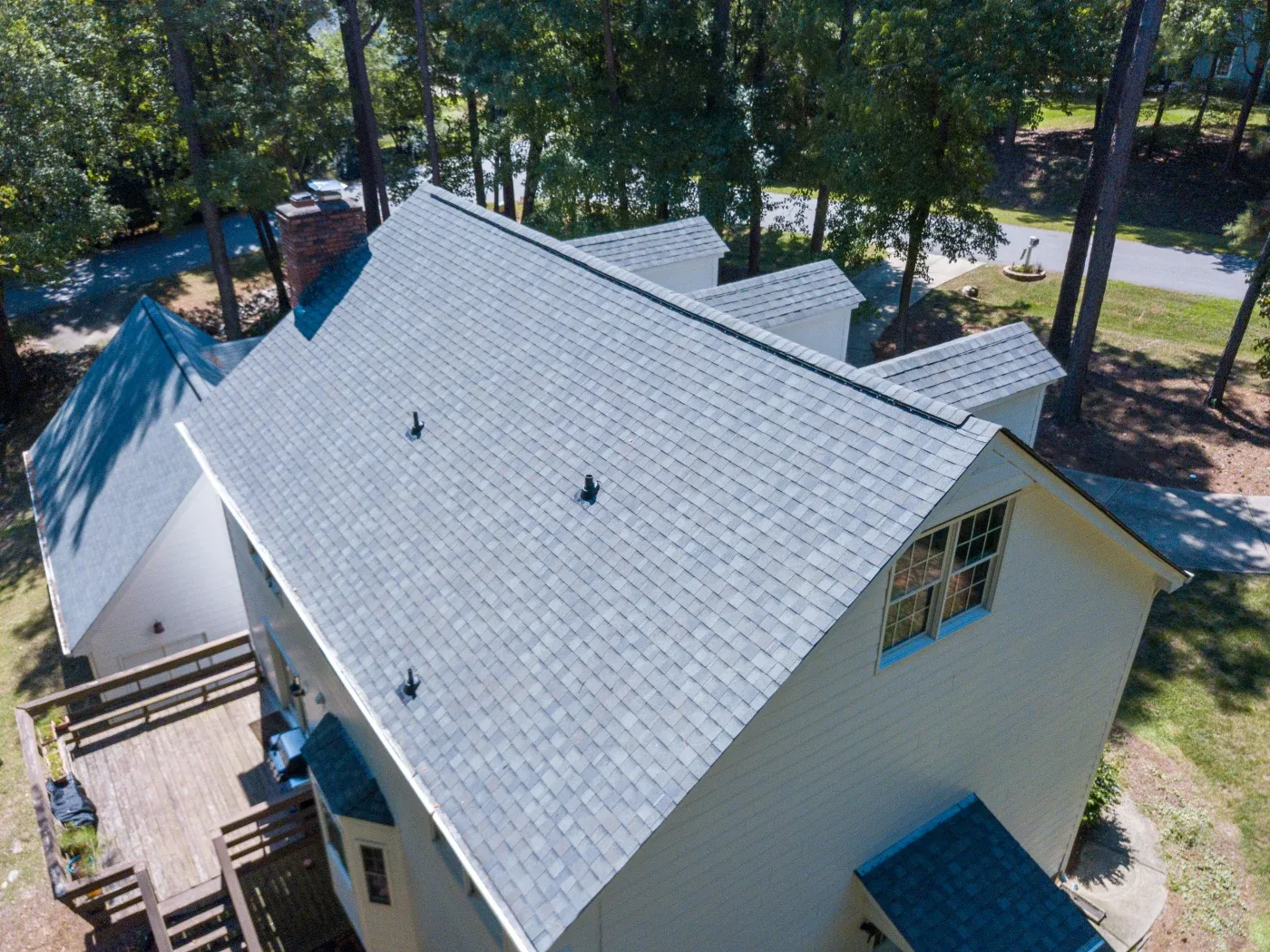 A detailed view of a newly installed asphalt shingle roof, showing crisp edges and vent installations.