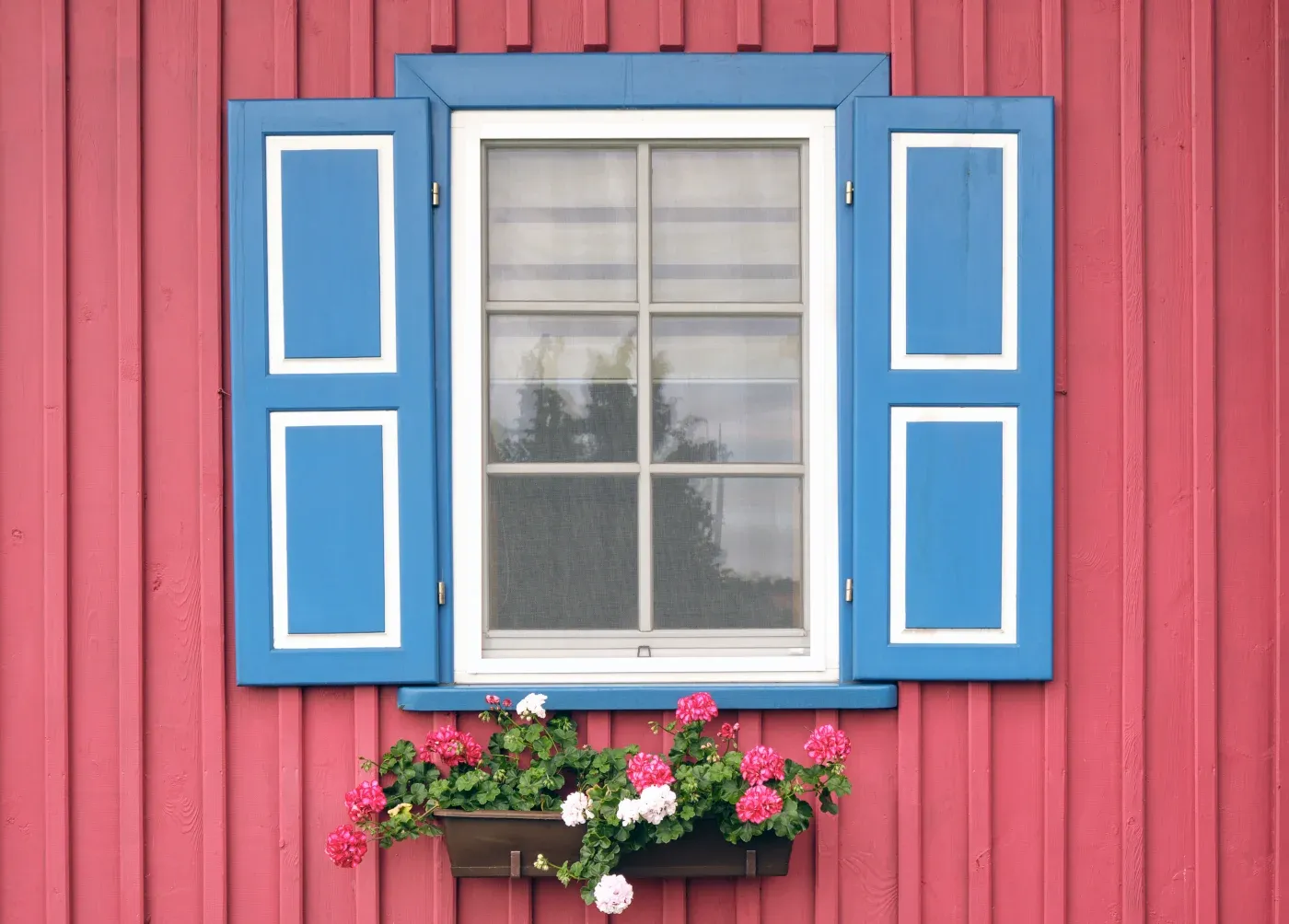 Wooden House Window With Open Shutters And Blooming Flowers Pot