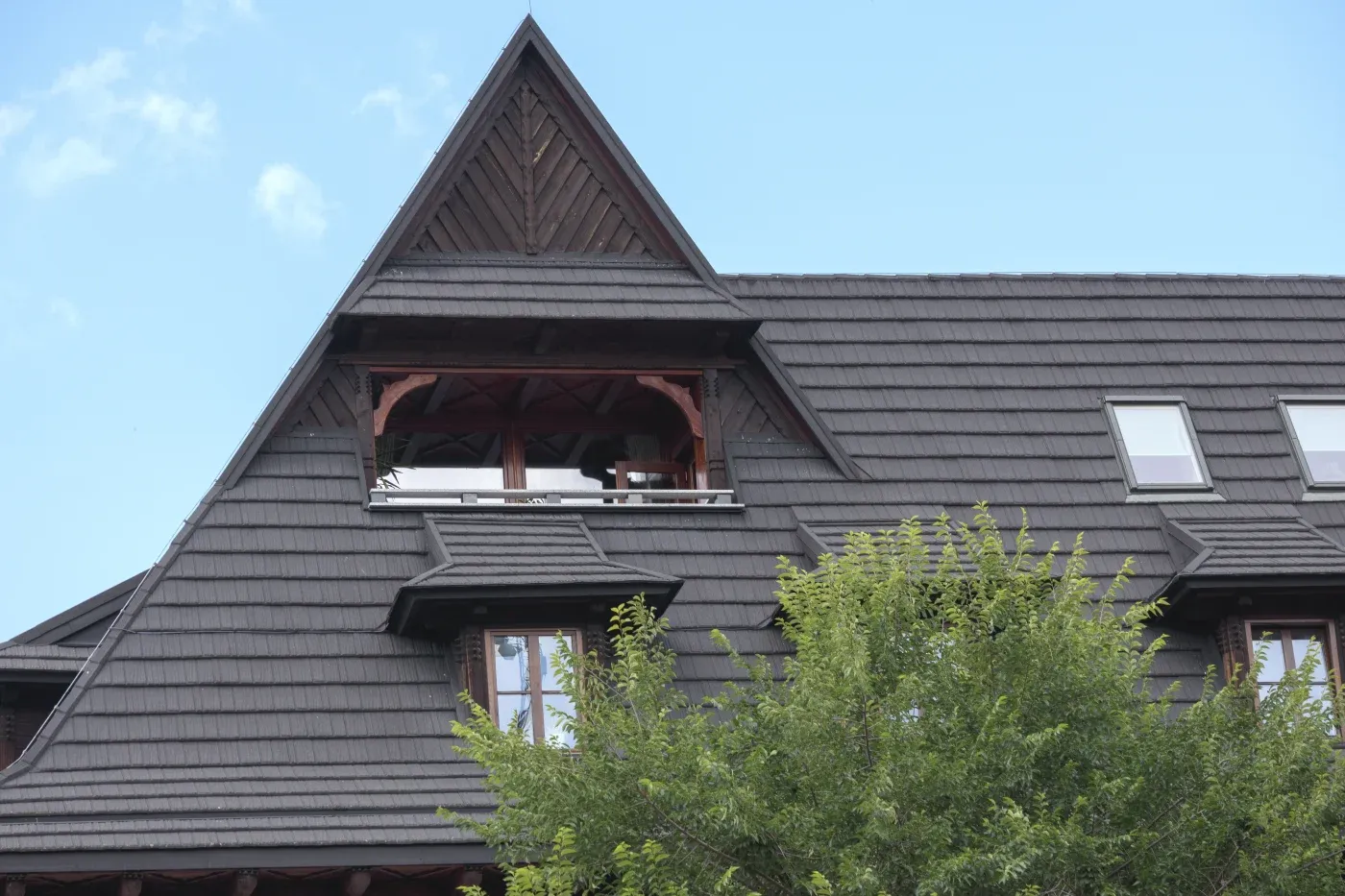 A brown roof on a house with several windows.