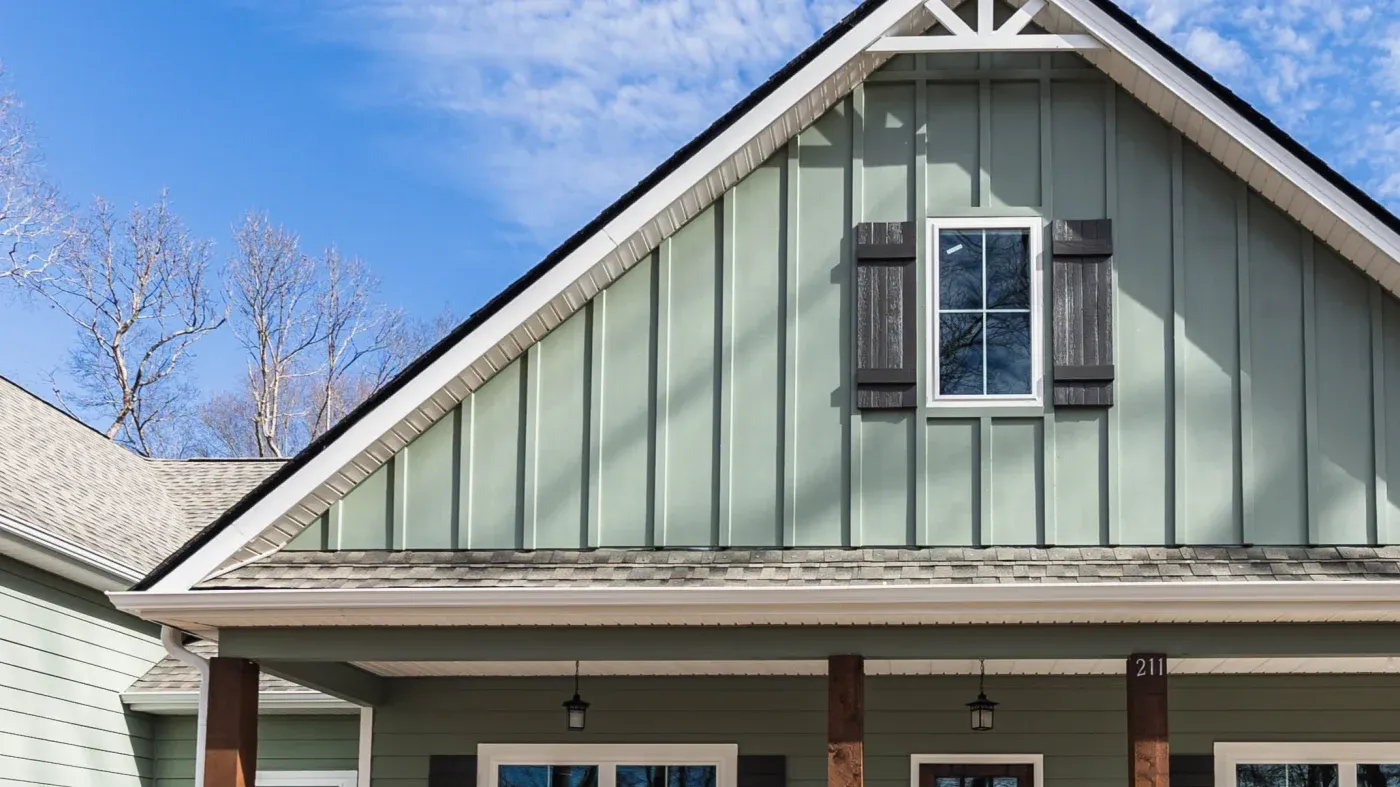 A close-up of brown rain gutters along a house with stone siding.