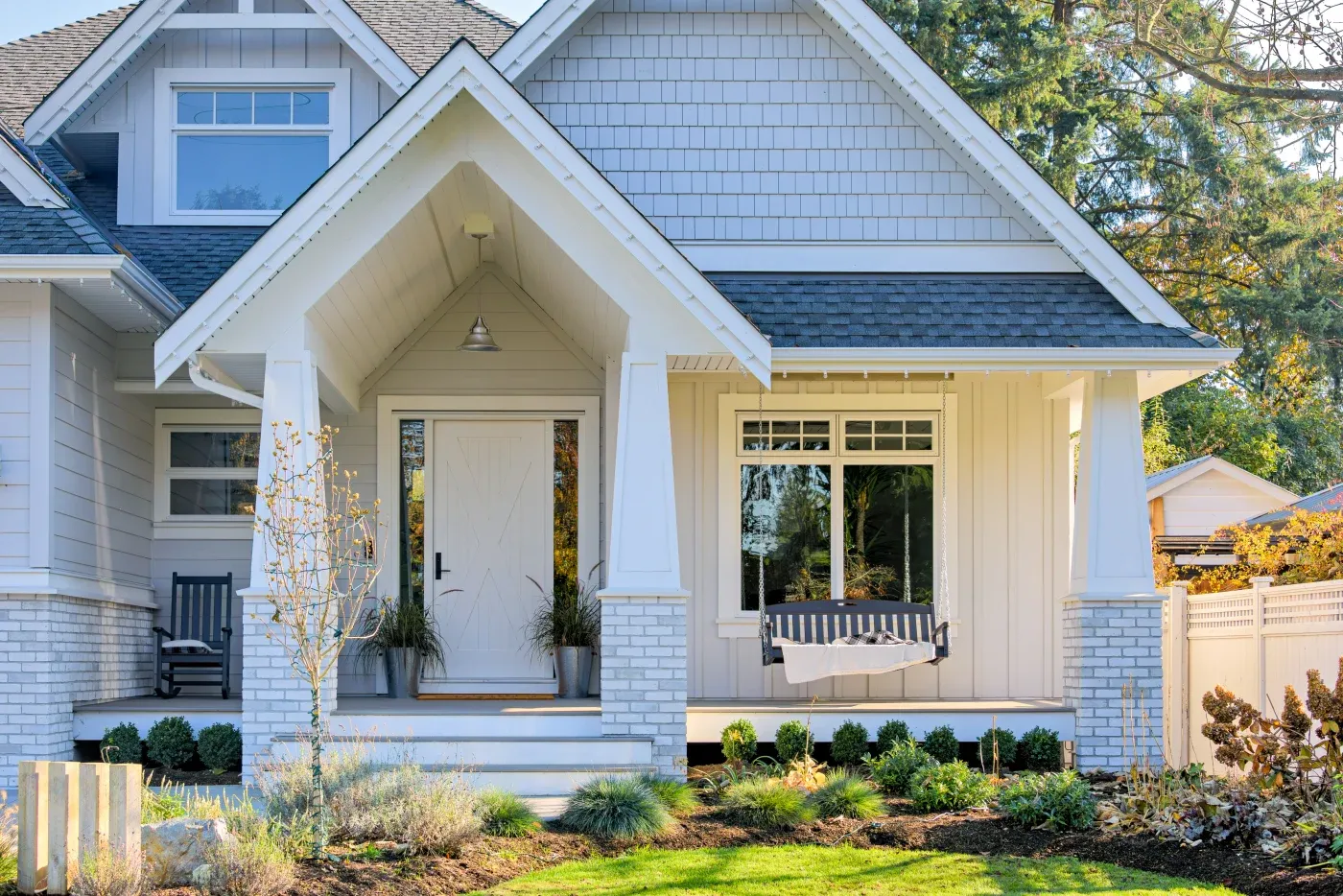 A house with white James Hardie siding and stone columns on the front porch.