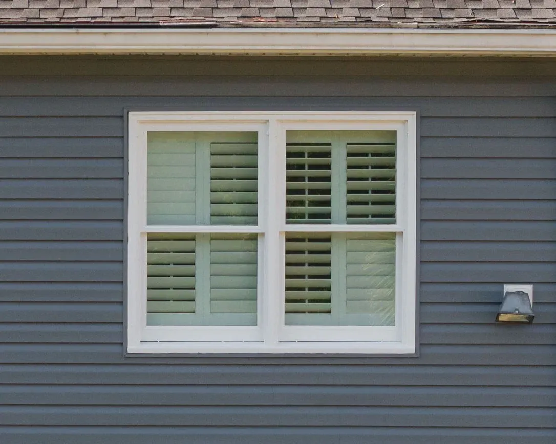 A newly installed window in a North Atlanta home with green siding.