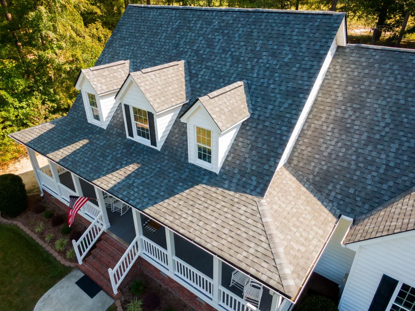 A wide shot of a newly shingled roof on a classic two-story home.