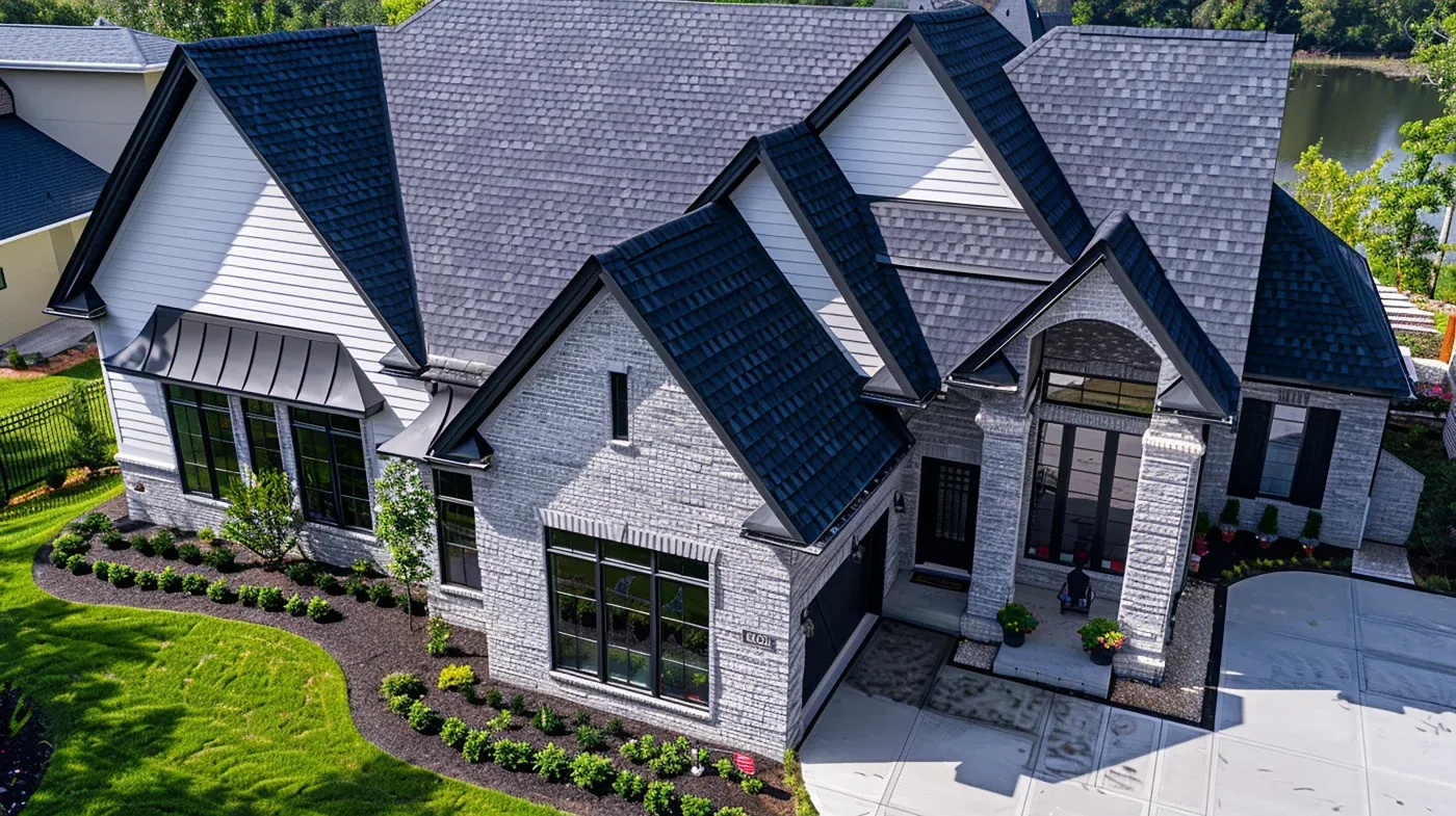 A large house with various windows and an asphalt shingle roof.