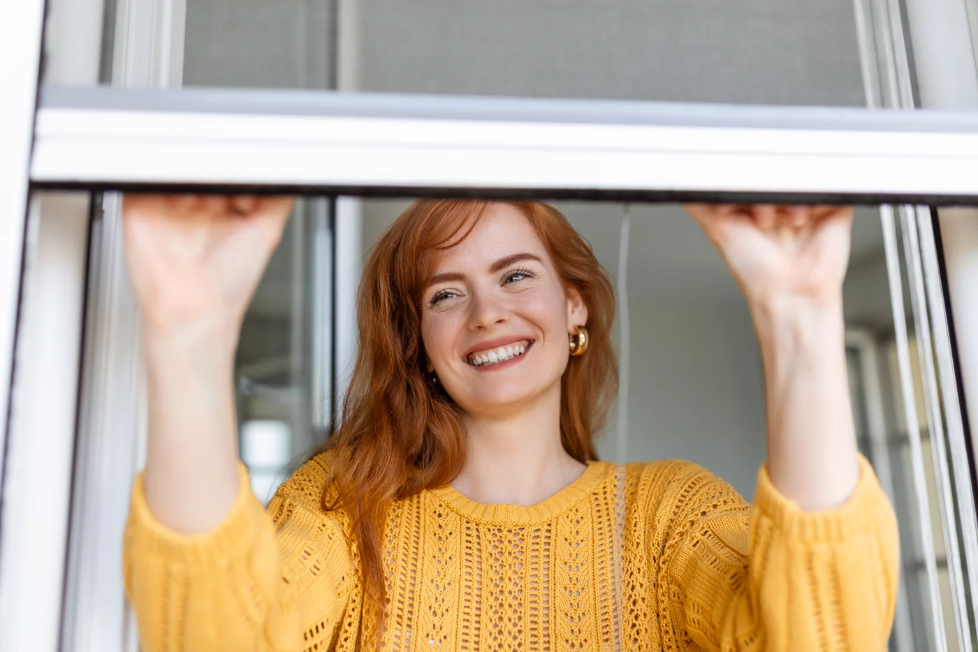 A homeowner opening a newly replaced custom-fit window