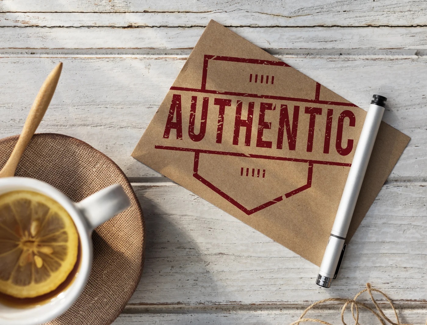 A cup of tea beside a small sign that reads Authentic