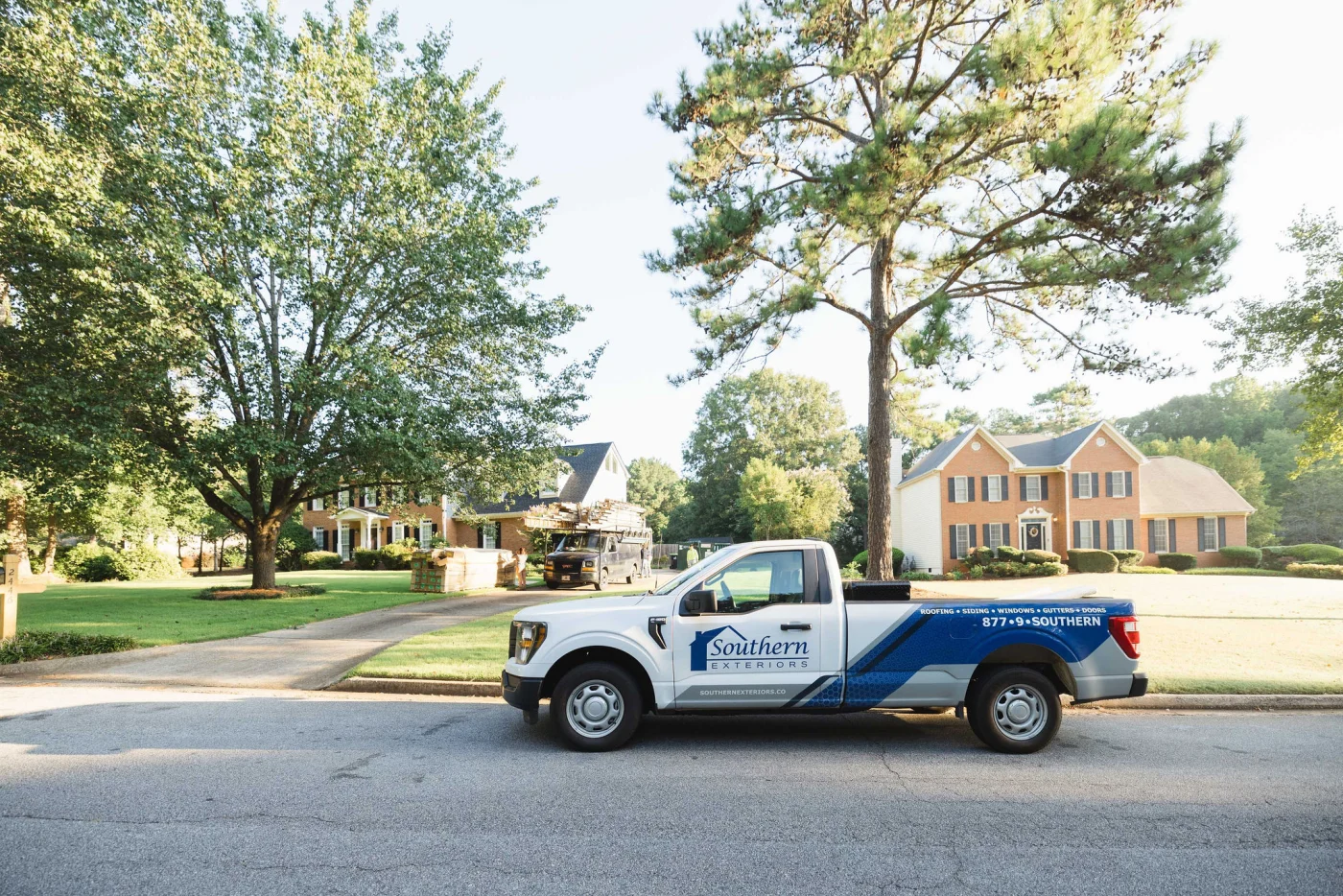 A company service truck branded with Southern Exteriors signage is parked along a residential street where a professional remodeling contractor is preparing for a neighborhood project.